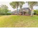 Expansive backyard with mature trees, well-maintained lawn, and a screened-in porch, perfect for outdoor relaxation at 6950 Vintage Ln, Port Orange, FL 32128
