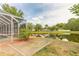 A hammock rests on a grassy lawn alongside a backyard pond with lush landscaping, offering a serene escape at 6950 Vintage Ln, Port Orange, FL 32128