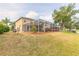 Home exterior showing a screened-in lanai, patio, trees, pond, and hammock at 6950 Vintage Ln, Port Orange, FL 32128