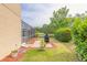 Backyard with a screened-in lanai, grill, and landscaping overlooking the pond at 6950 Vintage Ln, Port Orange, FL 32128
