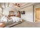 This primary bedroom showcases a tray ceiling, TV, and wood furniture creating a relaxing and inviting space at 6950 Vintage Ln, Port Orange, FL 32128