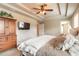 A bedroom with a tray ceiling features a television, armoire, and plush bedding, offering comfortable living at 6950 Vintage Ln, Port Orange, FL 32128