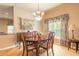 Formal dining room with a chandelier, decorative window treatments, and hardwood floors at 6950 Vintage Ln, Port Orange, FL 32128