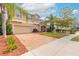 Charming two-story home with a well-manicured lawn, a brick driveway, and mature landscaping, offering curb appeal at 6950 Vintage Ln, Port Orange, FL 32128