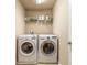 Laundry room featuring a side-by-side washer and dryer and storage shelf at 6950 Vintage Ln, Port Orange, FL 32128