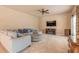 Comfortable living room featuring neutral carpet, a ceiling fan, and a decorative entertainment center at 6950 Vintage Ln, Port Orange, FL 32128