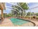 Inviting pool with a screened enclosure, brick paver decking, and lush landscaping overlooking the backyard at 6950 Vintage Ln, Port Orange, FL 32128