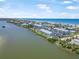 Stunning aerial view of coastal condos alongside serene waters, near the beach, under a bright blue sky with scattered clouds at 845 Ladyfish Ave # B204, New Smyrna Beach, FL 32169