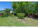 Lush backyard features well-maintained lawn, mature trees, and a charming garden at 913 Palmetto St, New Smyrna Beach, FL 32168