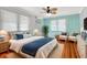Bright bedroom with hardwood floors, a ceiling fan, and two cozy armchairs at 913 Palmetto St, New Smyrna Beach, FL 32168