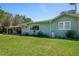 Exterior side view showcases the home's well-kept lawn, siding, and outdoor patio area at 913 Palmetto St, New Smyrna Beach, FL 32168