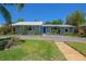 Inviting single-story home featuring a blue front door, metal roof, and verdant lawn at 913 Palmetto St, New Smyrna Beach, FL 32168