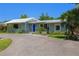 Charming single story home with a metal roof, lush landscaping and a large driveway at 913 Palmetto St, New Smyrna Beach, FL 32168