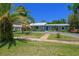 Charming single-story home featuring lush landscaping, a blue door, and a spacious front yard at 913 Palmetto St, New Smyrna Beach, FL 32168