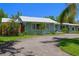 Attractive single-story home featuring a metal roof, palm trees, and well-maintained landscaping at 913 Palmetto St, New Smyrna Beach, FL 32168