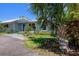 Charming home with a blue front door and tropical landscaping at 913 Palmetto St, New Smyrna Beach, FL 32168