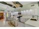 Clean white kitchen with stainless appliances, stone countertops, and cozy eat-in breakfast bar seating at 913 Palmetto St, New Smyrna Beach, FL 32168