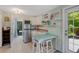 This partial kitchen includes a stainless steel refrigerator and a table with seating for two at 913 Palmetto St, New Smyrna Beach, FL 32168