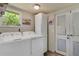 Well-lit laundry room with a washer, a dryer, a window, and a door with access to the outdoors at 913 Palmetto St, New Smyrna Beach, FL 32168