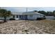 Single-story home featuring a white brick facade, manicured lawn, trimmed bushes, and an attached two-car garage at 1077 Willow Wood Dr, Port Orange, FL 32129