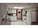Functional kitchen with white appliances, a cozy layout, and ample cabinet space for storage at 1077 Willow Wood Dr, Port Orange, FL 32129