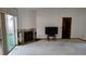 A spacious living room featuring neutral carpeting, a fireplace, and sliding glass doors to the outdoor patio at 1077 Willow Wood Dr, Port Orange, FL 32129
