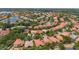 A beautiful aerial view of a community with mature trees and terracotta tile roofs, showcasing its beauty at 11222 Rapallo Ln, Windermere, FL 34786