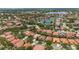 Community aerial view featuring lush landscaping, a pool, tennis courts, and homes with terracotta tile roofs at 11222 Rapallo Ln, Windermere, FL 34786