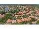 Expansive aerial view showcasing the property's location within a verdant, well-maintained community and serene pond at 11222 Rapallo Ln, Windermere, FL 34786