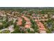 Expansive aerial view of a residential community featuring terracotta roofs, mature trees, and winding streets at 11222 Rapallo Ln, Windermere, FL 34786