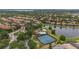 Expansive aerial view shows community amenities: pool, tennis courts, a playground, and a landscaped entrance at 11222 Rapallo Ln, Windermere, FL 34786