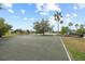 Community amenities featuring a basketball court and playground next to a picturesque lake and palm trees at 11222 Rapallo Ln, Windermere, FL 34786