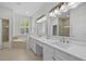 Elegant bathroom with double sinks, a vanity, soaking tub, walk-in shower, and ample natural light at 11222 Rapallo Ln, Windermere, FL 34786