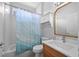 Bright bathroom featuring a tub, white vanity, and a blue patterned shower curtain at 11222 Rapallo Ln, Windermere, FL 34786