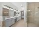 Bright bathroom featuring a dual vanity, frameless glass shower, and access to the main bedroom at 11222 Rapallo Ln, Windermere, FL 34786