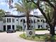 An impressive white building featuring a well manicured lawn, palm trees, and black car in the driveway at 11222 Rapallo Ln, Windermere, FL 34786