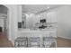 Stylish kitchen features white cabinets, quartz countertops, bar stool seating, and stainless steel appliances at 11222 Rapallo Ln, Windermere, FL 34786
