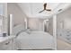 Well-lit main bedroom with neutral walls, tray ceiling, fan, carpet, and a view of the ensuite bathroom at 11222 Rapallo Ln, Windermere, FL 34786