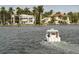 Gorgeous waterfront homes featuring manicured lawns, mature palms, and private docks on a sunny day at 11222 Rapallo Ln, Windermere, FL 34786