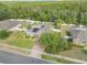 Aerial view of a home showcasing a well-manicured lawn, fenced yard, and solar panels, nestled in a wooded neighborhood at 115 Los Arbor Dr, Deland, FL 32724
