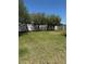 Large grassy backyard is perfect for outdoor activities, bordered by a white fence and mature trees, offering privacy at 115 Los Arbor Dr, Deland, FL 32724