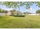 Spacious backyard featuring lush green grass, privacy fence, and mature trees, creating a serene outdoor oasis at 115 Los Arbor Dr, Deland, FL 32724