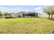 Expansive backyard with a screened-in patio, storage shed, and ample green space for entertainment and recreation at 115 Los Arbor Dr, Deland, FL 32724