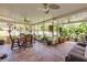 Large, screened patio with ample seating, plants, ceiling fans, and a concrete floor at 115 Los Arbor Dr, Deland, FL 32724