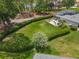Aerial view of a large backyard featuring a verdant lawn, privacy hedges, and a patio with a screened enclosure at 1156 Rivercrest Ct, Port Orange, FL 32128