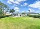 Expansive backyard featuring a lush lawn, manicured hedges, and a charming patio area with a screened-in lanai at 1156 Rivercrest Ct, Port Orange, FL 32128