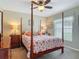 Cozy bedroom with a four-poster bed, seashell bedding, and a ceiling fan for comfort at 1156 Rivercrest Ct, Port Orange, FL 32128