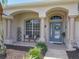 Inviting front porch featuring arched columns, seating, and a decorative blue front door at 1156 Rivercrest Ct, Port Orange, FL 32128