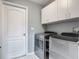 Well-organized laundry room with modern washer and dryer and extra storage cabinets at 1156 Rivercrest Ct, Port Orange, FL 32128