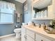 Bathroom with white vanity, decorative fixtures, framed mirror, and blue walls at 116 Duck Hawk Cir # 3040, Daytona Beach, FL 32119